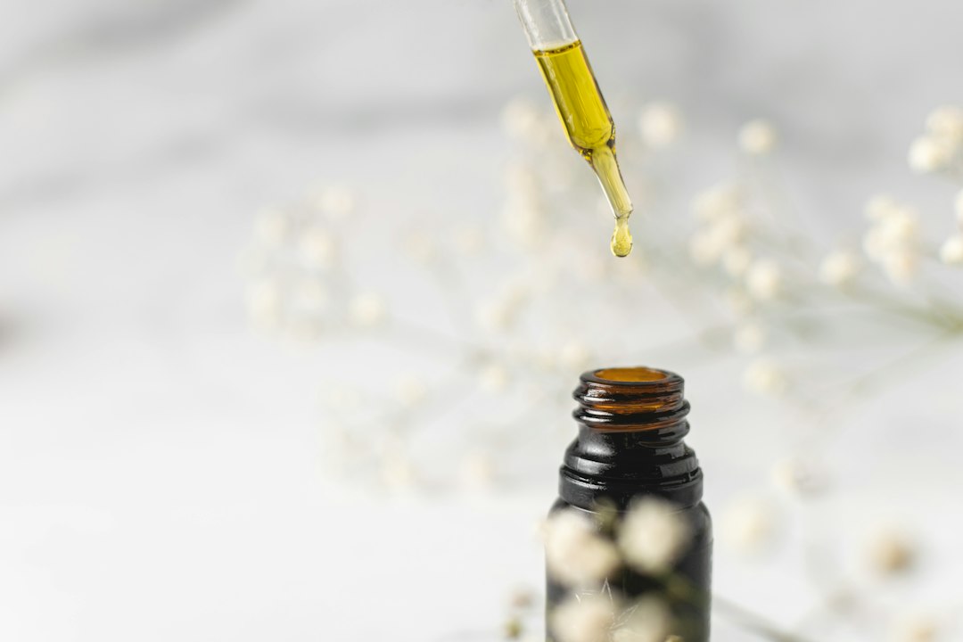 Dropper releasing liquid extract into an amber bottle, a staple format in the herbal tincture market